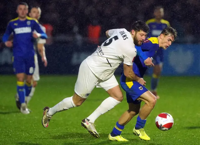 Boreham Wood's Will Evans (left) and AFC Wimbledon's Luke McCormick battle for the ball