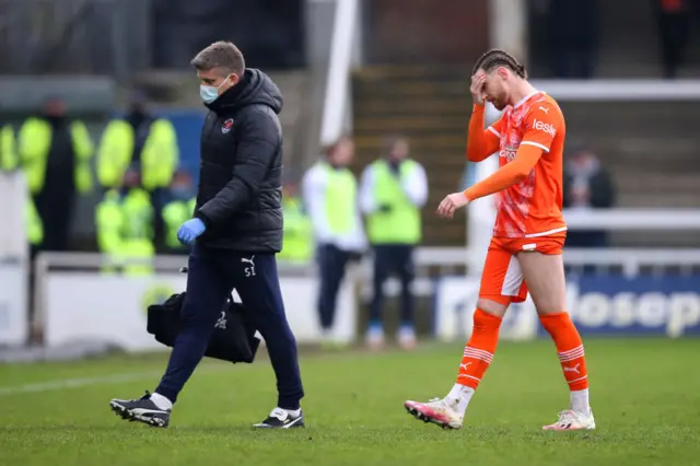 James Husband of Blackpool reacts upon leaving the pitch with an injury