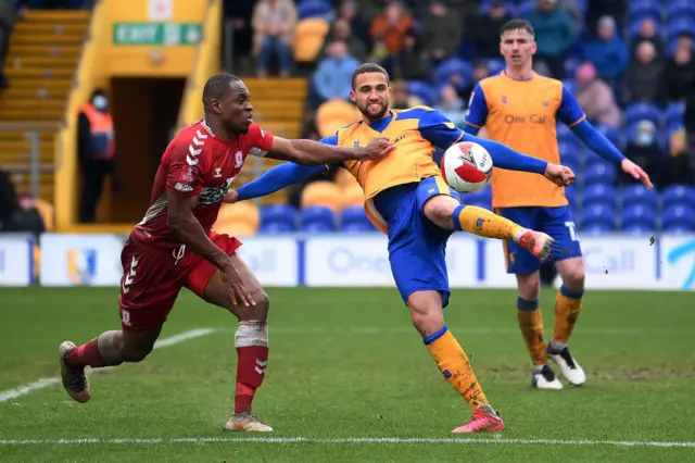 ordan Bowery of Mansfield Town is tackled by Uche Ikpeazu of Middlesborough