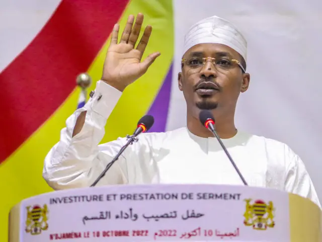 Mahamat Idriss Deby raises his hand as he is sworn in as Chad's transitional president, in NDjamena on October 10, 2022.