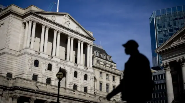 People walk past the Bank of England in London