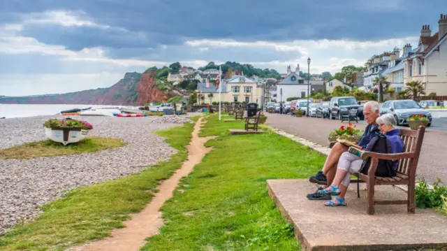 Pensioners reading on a seaside bench