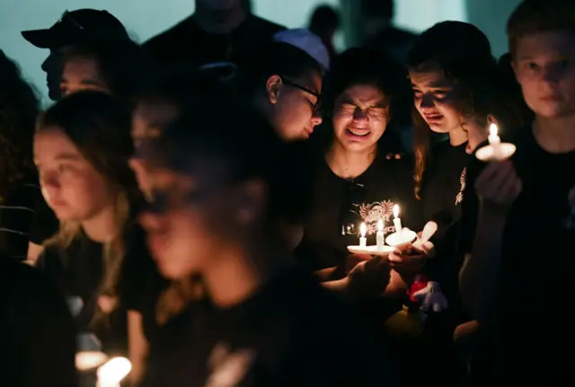 Students crying at a candlelight vigil for Parkland shooting victims