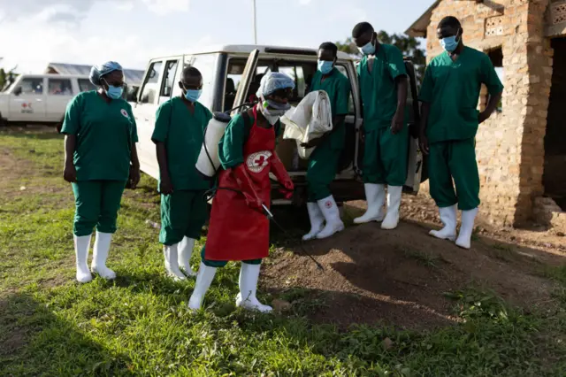 Ugandan Red Cross workers put on PPE prior to a Safe and Dignified Burial on October 11, 2022 in Mubende, Uganda.