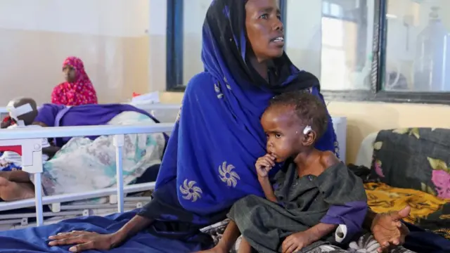 Hajira Ali, a Somali woman displaced by the worsening drought due to failed rain seasons, holds her malnourished child Farhia Hassan, 2, at the paediatric ward in the Banadir Hospital of Mogadishu, Somalia September 24, 2022.