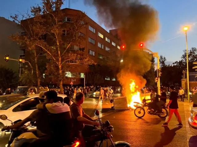 A police motorcycle burns during a protest in Tehran on 19 September