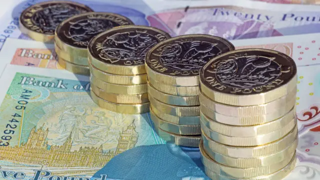 Five stacks of one pound coins arranged in increasing height on British pound notes