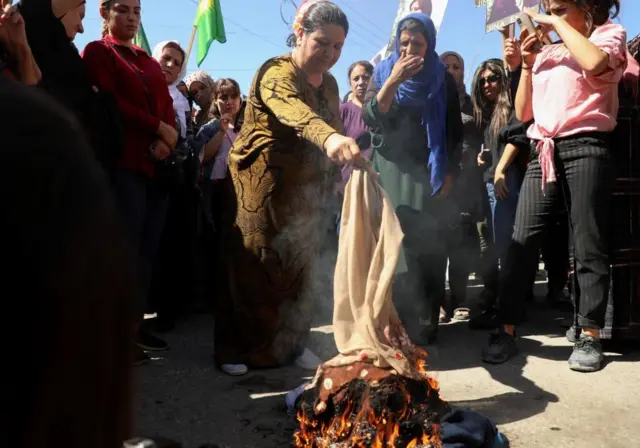 Women burn headscarves in the Kurdish-controlled city of Qamishli, north-eastern Syria on 26 September