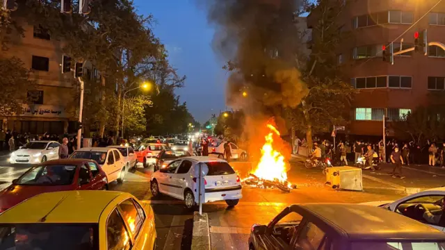 A police motorcycle burns during a protest in Tehran, Iran. Photo: 19 September 2022