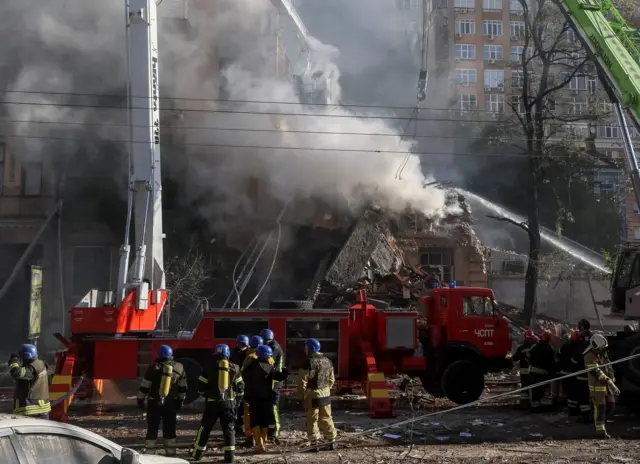 Smoke pours out of a building as firefighters try to fight the blaze caused by drone strikes