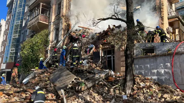 Rescue workers search the rubble of a destroyed block of flats