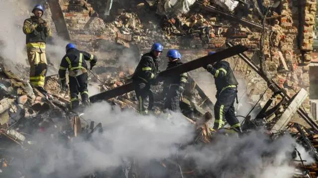 Rescue workers search smouldering rubble after a Russian drone strike in Kyiv