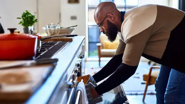 Man reaching into oven