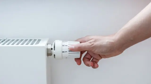 Person turning on radiator