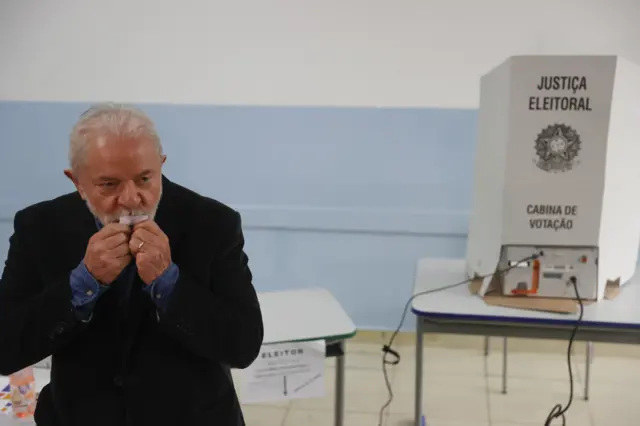 Left-wing candidate and ex-president Luiz Inácio 'Lula' da Silva kisses his electoral confirmation slip after voting in São Paulo