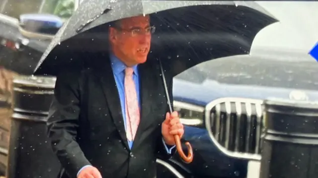 Brady under an umbrella arriving at Downing Street