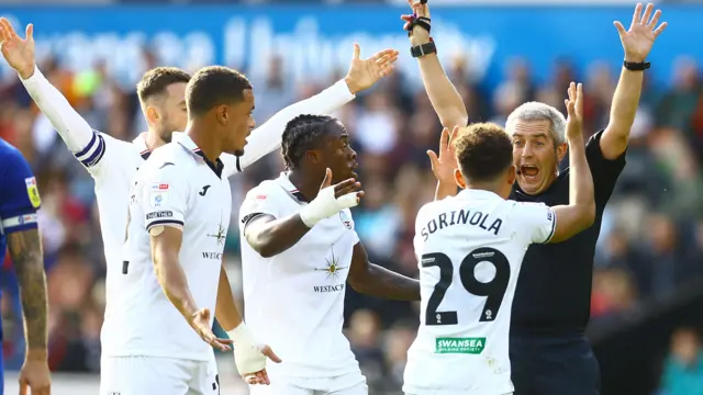 Swansea players complain to referee Darren Bond