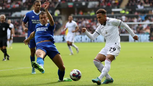 Tom Sang of Cardiff (left) tries to block Matty Sorinola of Swansea (right)