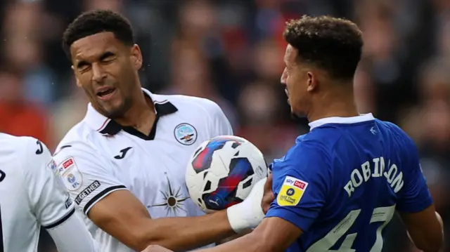 Callum Robinson (right) of Cardiff throws the ball at Swansea's Ben Cabango (left)