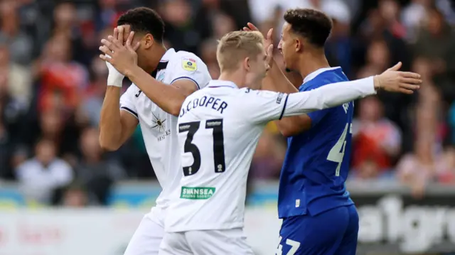 Callum Robinson (right) of Cardiff throws the ball at Swansea's Ben Cabango (left)