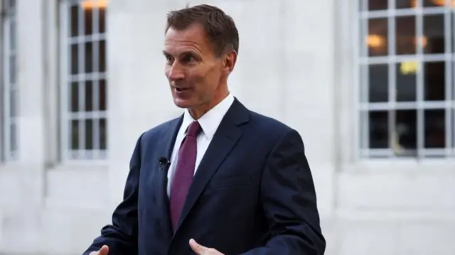 British Chancellor of the Exchequer Jeremy Hunt speaks during an interview with television correspondent Robert Peston outside the BBC headquarters, in London,