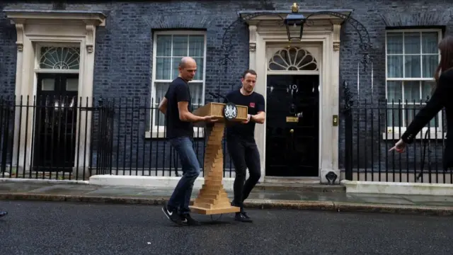 Staff lift a podium in-front of Number 10 Downing Stree