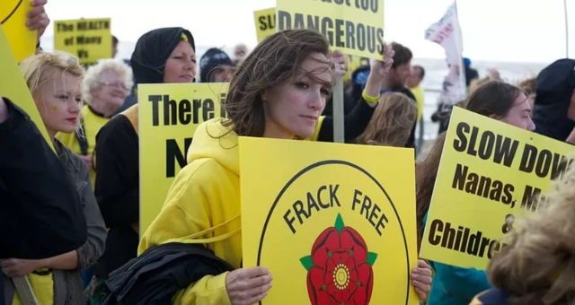 Protesters with placards demonstrate against fracking