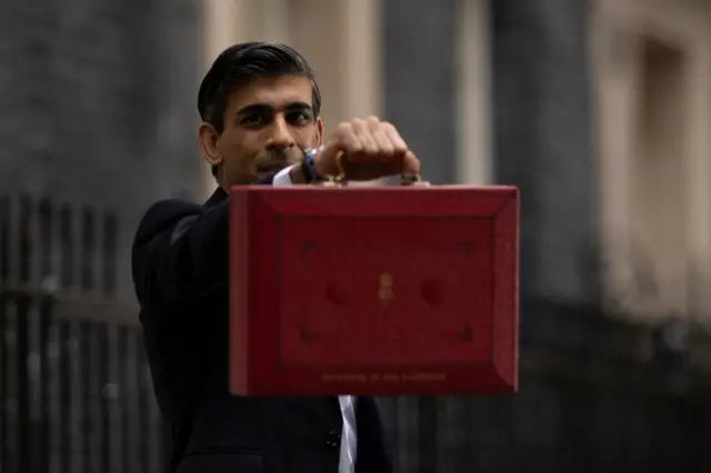 File photo of Rishi Sunak holding up the red Budget box