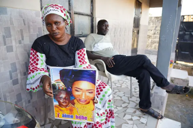 Mariama Kuyateh, 30, holds up a picture of her late son Musawho died from acute kidney failure