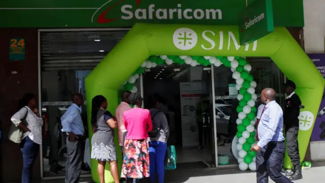 Customers queue outside the Safaricom mobile phone customer care centre during the launch of its 5G internet service in the central business district of Nairobi