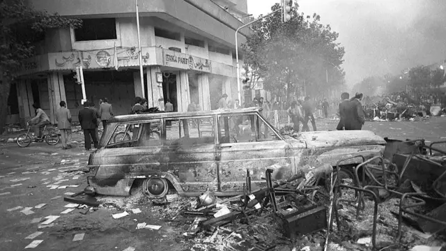 A burnt out car on the street after a day of demonstrations in Tehran in 1978