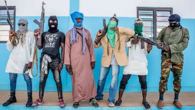 Togolese policemen, disguised as a terrorists, hold their weapons on October 20, 2022 as they take part in an anti-terrorism exercise.