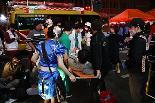 Medics carry injured people into ambulances after the crush