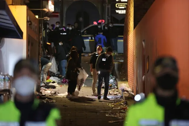 Police investigators scrutinise an alley following the deadly incident in Seoul