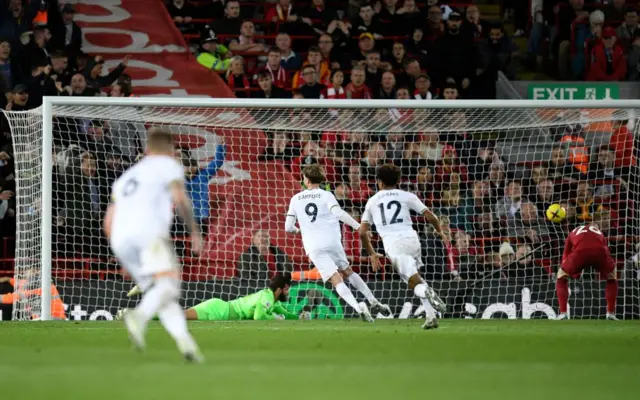 Liverpool's Brazilian goalkeeper Alisson Becker watches as the ball hits the back of the net as Leeds United's Dutch striker Crysencio Summerville