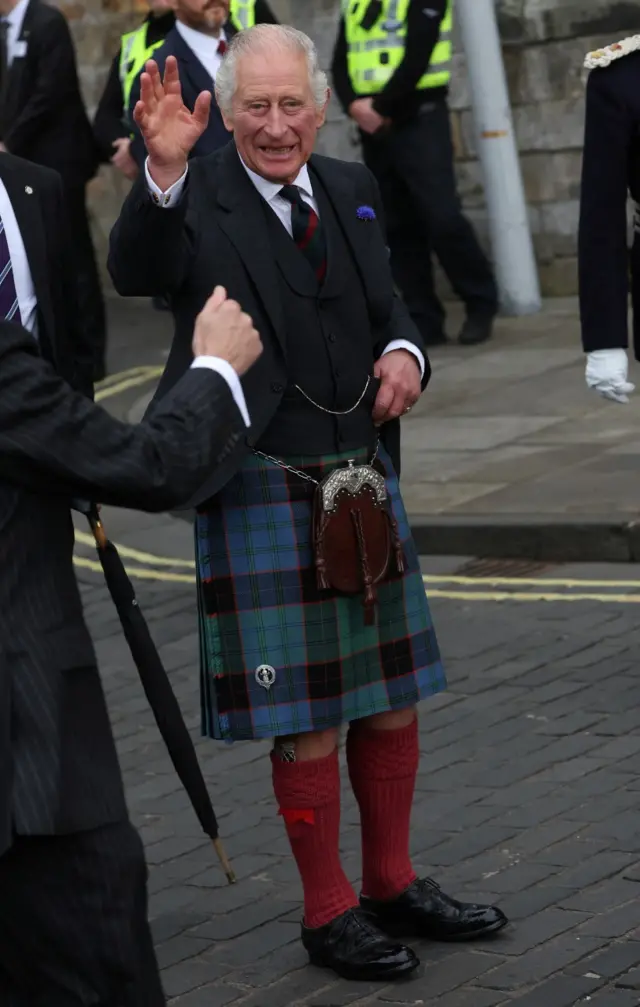 King Charles, wearing his kilt, greets the crowds as he arrives in Dunfermline