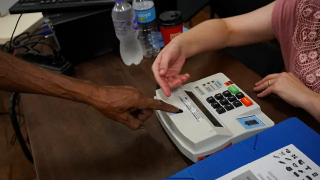 Voter getting their finger prints checked