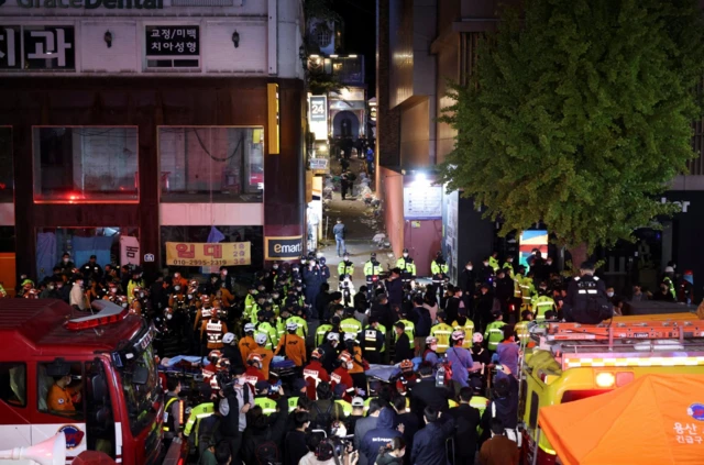 Rescue team and firefighters work at the scene where dozens of people were injured in a stampede during a Halloween festival in Seoul