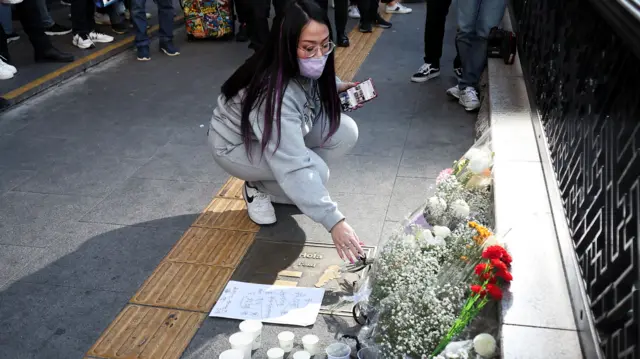 A woman pays tribute near the scene of the disaster