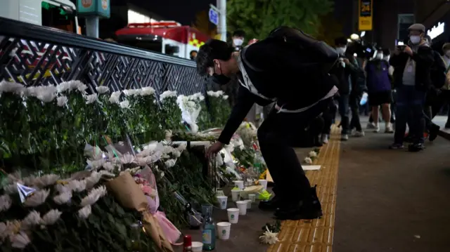 A man leaves flowers near the scene