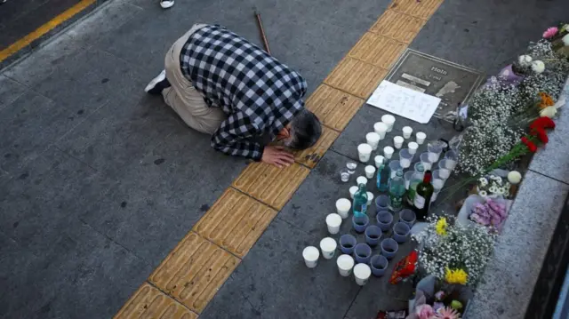 Person pays tribute near to the scene of a fatal stampede in Seoul