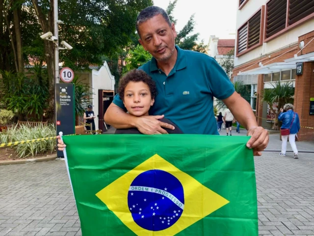 Franklin poses with a the Brazilian flag and his son