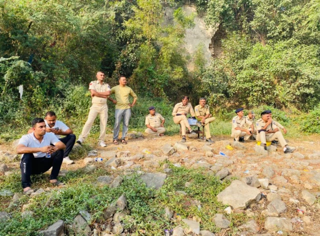 Rescue personnel wait by the riverside in Morbi