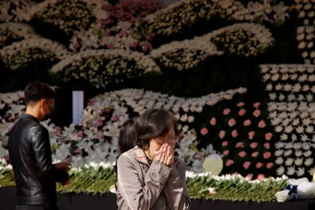 A person mourns at a group memorial for the victims of a stampede during a Halloween festival, at Seoul City Hall Plaza in Seoul, South Korea, October 31, 2022.