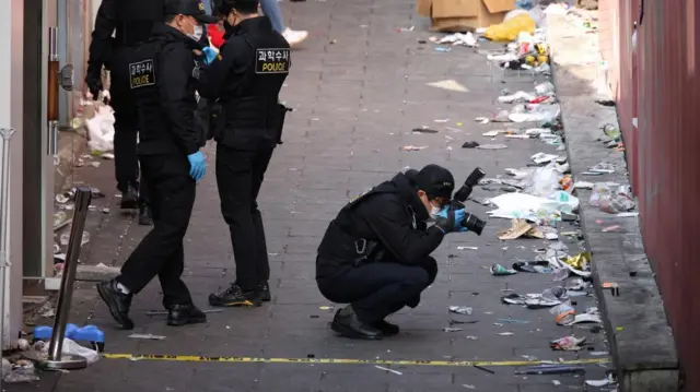 Investigators inspect the scene of a stampede that happened during Halloween festivities, in Seoul, South Korea