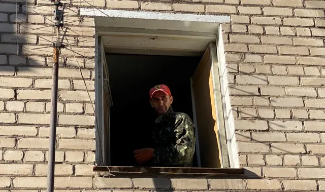 Pavlo stands at an empty window