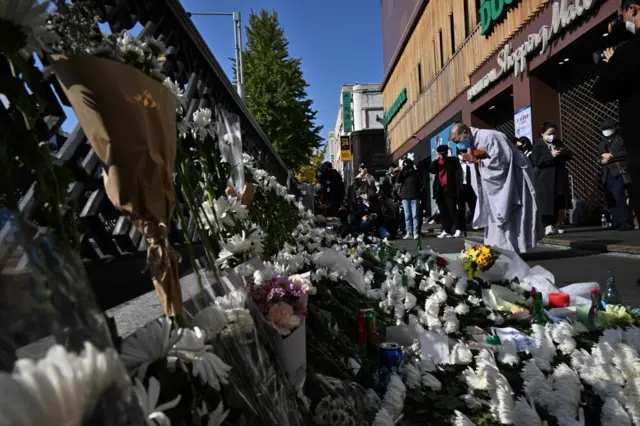 A Buddhist nun prays in tribute to those who were killed, at a makeshift memorial outside a subway station in the district of Itaewon in Seoul on October 31, 2022, two days after a deadly Halloween crush in the area.