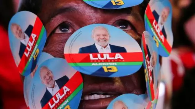 A supporter of Brazil's former president and presidential candidate Luiz Inacio Lula da Silva displays stickers on his face while gathering with fellow supporters o