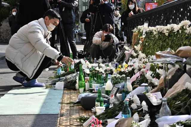 Mourners leave alcohol and flowers behind