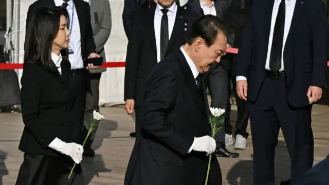 South Korean President Yoon Suk-yeol (R) and his wife Kim Keon-hee (L) visit a joint memorial altar for the victims of the deadly Halloween crush, in front of the city hall in Seoul on October 31, 2022